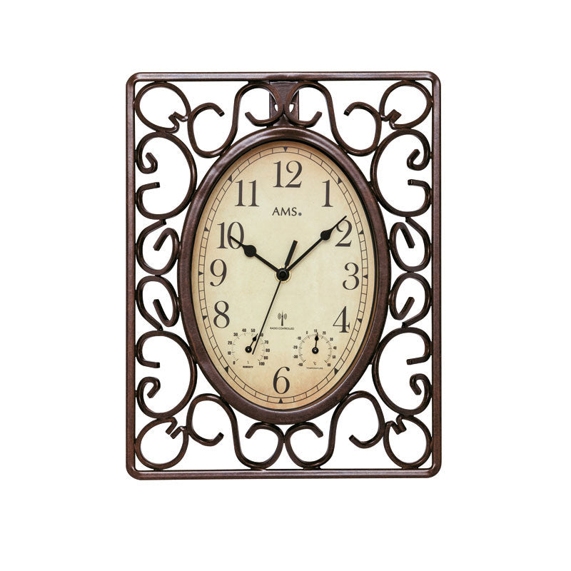 Horloge murale ancienne avec cadran ovale et cadre métallique orné, fond crème