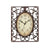 Horloge murale ancienne avec cadran ovale et cadre métallique orné, fond crème