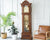 Pendule en bois marron avec une zone vitrée ouverte sur le devant et un mécanisme de sonnerie doré