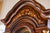 Gros plan de la couronne d'horloge de parquet en bois avec marqueterie florale et cadre incurvé