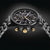 Schwarze Herrenarmbanduhr mit Chronographen-Zifferblatt, goldfarbener Lünette und Metallarmband