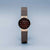 Montre pour femme avec cadran rond noir, boîtier couleur or rose et bracelet milanais.