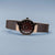 Montre pour femme avec cadran noir, boîtier couleur or rose et bracelet milanais large.