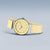Montre pour femme avec cadran jaune et bracelet beige, boîtier plat avec lunette argentée
