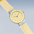 Montre pour femme avec cadran rond jaune et bracelet beige, couronne latérale