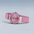 Montre pour femme de face avec bracelet rose, lunette ronde et cadran orné de pierres