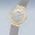 Montre pour femme avec cadran argenté et lunette dorée, bracelet milanais