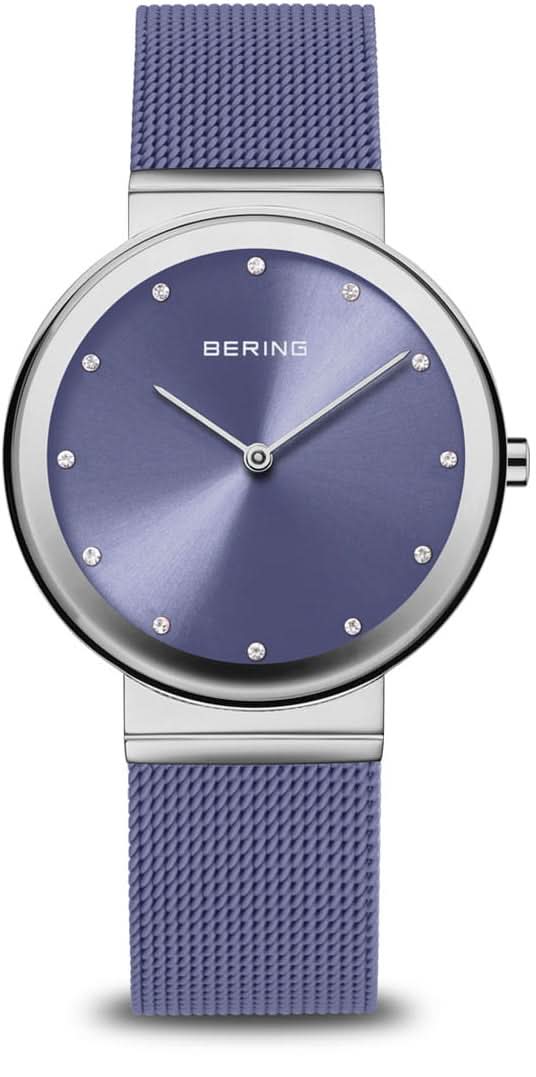 Montre pour femme avec bracelet milanais violet, boîtier rond argenté et cadran bleu.