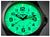 Montre pour homme en gros plan : cadran vert lumineux avec aiguilles et chiffres.