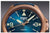 Nahaufnahme Herrenuhr mit blauem Zifferblatt, Leuchtindizes und Automatik-Symbol