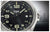 Cadran de montre homme, noir avec index luminescents et aiguilles argentées.