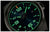 Gros plan d'une montre pour homme : cadran noir avec aiguilles et index luminescents verts.