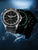 Herrenuhr mit schwarzem Zifferblatt und grünen Leuchtmarkierungen, schwarzes Silikonband