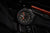 Montre pour homme avec bracelet noir, aiguilles lumineuses sur cadran sombre sur le côté