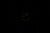 Index et aiguilles verts lumineux d'une montre sur fond sombre