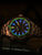 Bracelet de montre pour homme Traser avec lunette couleur bronze et index lumineux bleus, accentués de vert