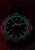 Montre-bracelet pour homme avec anneau lumineux vert, lunette noire et accent rouge sur le bracelet