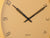 Gros plan d'une horloge murale avec un cadran jaune miel, des aiguilles et des chiffres noirs
