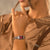 Am Handgelenk getragene Damenarmbanduhr Festina mit rotem Zifferblatt und Edelstahlband