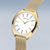 Jolie montre bracelet dorée avec cadran blanc, index colorés et bracelet milanais