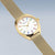 Montre bracelet dorée avec cadran blanc, index de couleur et bracelet milanais