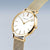 Montre pour femme avec cadran blanc, aiguilles rondes et bracelet milanais doré