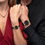 Deux montres pour femme avec cadran noir, bracelet noir et boîtiers en or rose