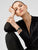 Montre pour femme au poignet : cadran noir, lunette or rose, bracelet noir