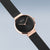 Montre pour femme avec cadran noir, lunette or rose et bracelet milanais noir