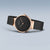 Montre femme de côté : cadran noir, couronne or rose, bracelet milanais noir