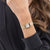 Goldfarbene Damenarmanduhr mit Steinbesatz am Gehäuse und Metallarmband