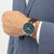 Herrenarmbanduhr am Handgelenk: blaues Zifferblatt mit Chrono-Subdials, braunes Lederband.