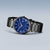 Montre homme avec cadran bleu et bracelet à maillons noirs, vue à trois quarts