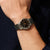 Solaruhr für Herren am Handgelenk mit Titanarmband, dunklem Zifferblatt und orangefarbenem Akzent.