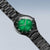 Montre homme de profil avec cadran vert, index blancs et bracelet en métal noir