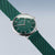 Montre homme en angle : cadran vert avec index, boîtier argenté, bracelet milanais