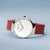 Herrenuhr mit silbernem Gehäuse, weißem Zifferblatt und rotem Silikonarmband (Seitenansicht)