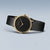 Montre Bering pour femme avec cadran noir, boîtier doré et bracelet milanais noir.