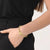 Bracelet cœur doré au poignet avec maillons de chaîne et fermoir magnétique