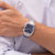 Tommy Hilfiger Armbanduhr am Handgelenk: blaues Zifferblatt, Edelstahlband