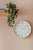 Horloge murale sur un mur avec un cadran blanc et un cadre jaune-vert