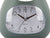 Gros plan d'un cadran analogique de réveil vert jungle, grands index des heures