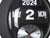 Vue de près d'une horloge murale noire avec chiffres rabattables 2024 et affichage analogique de l'heure