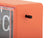 Horloge murale orange avec cadre transparent et bouton rotatif sur le côté