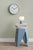 Horloge murale sur un mur avec un bord bleu et un cadran blanc, aiguilles vertes