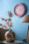 Horloge murale rose avec chiffres arabes et aiguilles sur le mur