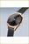 Montre pour femme avec cadran noir, lunette or rose, bracelet milanais en métal