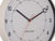 Gros plan d'une horloge murale ronde gris chaud avec des aiguilles noires et des lignes rouges