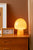 Réveil rectangulaire avec cadre ocre sur une commode en bois