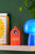 Coucou LED dans une maisonnette en bois orange sur une étagère, heure LED 12:25